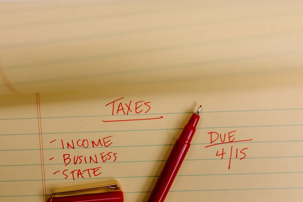 A legal pad with taxes written in red and a due date of April 15 circled.